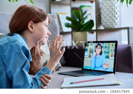 Online lesson, child girl looking at laptop screen, talking with teacher Online lesson, child girl looking at laptop screen, talking with teacher 108417945