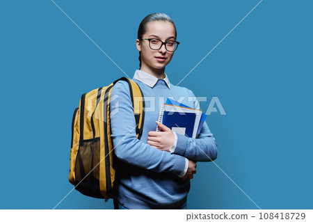 Portrait of teen girl high school student on blue studio background Portrait of teen girl high school student on blue studio background 108418729