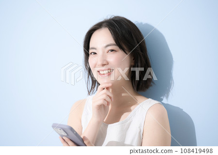 有智慧型手機的女性,背景清新藍色 有智慧型手機的女性,背景清新藍色 108419498