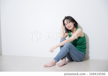 一位休閒女性坐著梳頭髮,看著鏡頭的全身護髮美容形象 一位休閒女性坐著梳頭髮,看著鏡頭的全身護髮美容形象 108419500