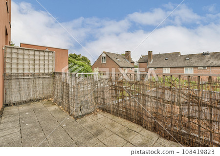 an outside area with fences and houses in the background on a cloudy day, as seen from behind it 108419823