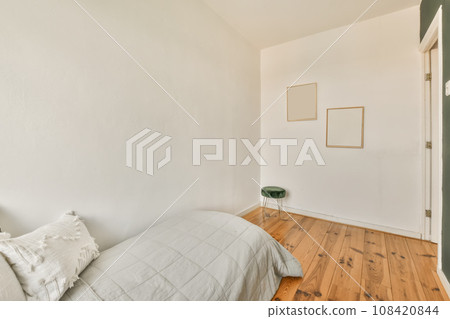 a bedroom with wood flooring and white walls, including a bed in the fore - image taken from above 108420844