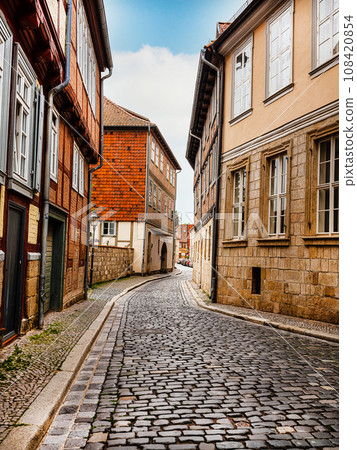 small town with old vintage small colored houses and old cobblestone pavement 108420854