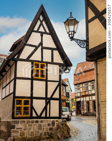 small town with old vintage small colored houses and old cobblestone pavement 108420857