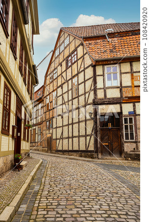 small town with old vintage small colored houses and old cobblestone pavement 108420920