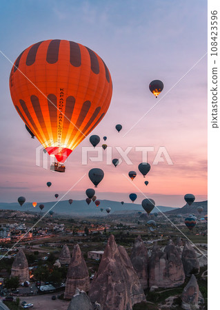 Scenery of hot air balloons taking off all at once during the famous sunrise time in Cappadocia, a tourist destination in Turkey Scenery of hot air balloons taking off all at once during the famous sunrise time in Cappadocia, a tourist destination in Turkey 108423596