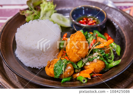 Stir-fried crispy chicken with basil and fish sauce chili is a popular Thai food 108425086