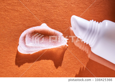 Hygienic moisturizing lip balm in a tube on a orange background. Hygienic moisturizing lip balm in a tube on a orange background. 108425366