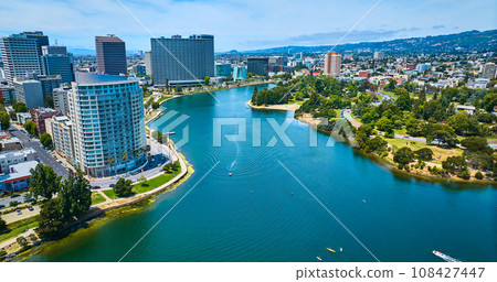Oakland downtown skyscrapers beside Merritt Lake aerial with multiple boats on water Oakland downtown skyscrapers beside Merritt Lake aerial with multiple boats on water 108427447