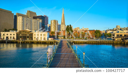 Aerial over Pier 7 sunrise golden glow over city skyscrapers with blue sky Aerial over Pier 7 sunrise golden glow over city skyscrapers with blue sky 108427717
