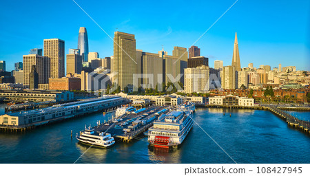 Aerial sunrise lighting over docked ships at Pier 7 with San Francisco skyscraper skyline Aerial sunrise lighting over docked ships at Pier 7 with San Francisco skyscraper skyline 108427945