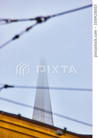 Barely visible tip of Transamerica Pyramid seen through fog and wires 108428083