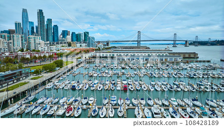 Aerial South Beach Harbor yachts and boats with Pier 40 and Oakland Bay Bridge with city 108428189