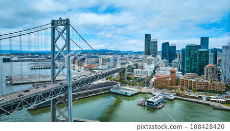 Oakland Bay Bridge aerial with view of city skyscrapers and San Francisco Fire Department Pier 108428420