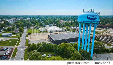 Bright blue Auburn water tower with city in distance on blue sky day aerial Bright blue Auburn water tower with city in distance on blue sky day aerial 108428561