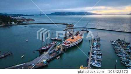 Hyde St Pier at dusk with golden edge on horizon ships in the harbor aerial Hyde St Pier at dusk with golden edge on horizon ships in the harbor aerial 108428570