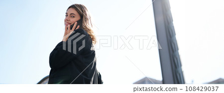 Portrait of stylish corporate woman talking on mobile phone, having a call while walking on street, going to office Portrait of stylish corporate woman talking on mobile phone, having a call while walking on street, going to office 108429037