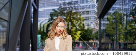 Portrait of confident ceo manager, young businesswoman in suit, looking determined and self-assured, posing on street on sunny day Portrait of confident ceo manager, young businesswoman in suit, looking determined and self-assured, posing on street on sunny day 108429932