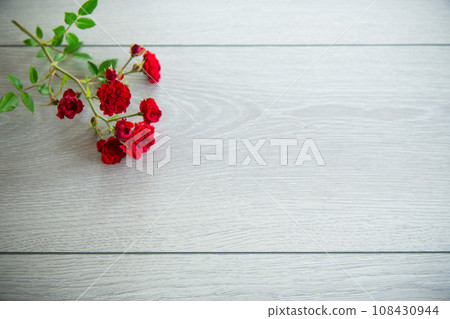 bouquet of red small roses, on a wooden background. 108430944