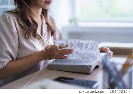 Young asian student in casual clothes reading textbook to studying education knowledge and doing homework assignments while wearing headphones and listening the music to relaxation in university Young asian student in casual clothes reading textbook to studying education knowledge and doing homework assignments while wearing headphones and listening the music to relaxation in university 108432564