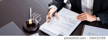Lawyer businesswoman reading lawsuit and checking about financial business document to taking notes while analysis about legislation agreement and terms data of business contract in law firm 108432589