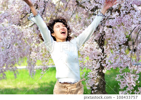 A woman stretching under the cherry blossoms A woman stretching under the cherry blossoms 108433757