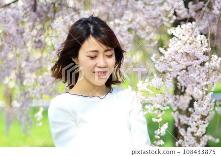 Young woman with cherry blossoms in the background Young woman with cherry blossoms in the background 108433875