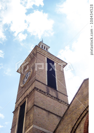 A historic brick building under blue skies and bright sunlight near Liverpool Street Station in London A historic brick building under blue skies and bright sunlight near Liverpool Street Station in London 108434528
