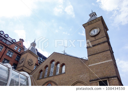 A historic brick building under blue skies and bright sunlight near Liverpool Street Station in London A historic brick building under blue skies and bright sunlight near Liverpool Street Station in London 108434530