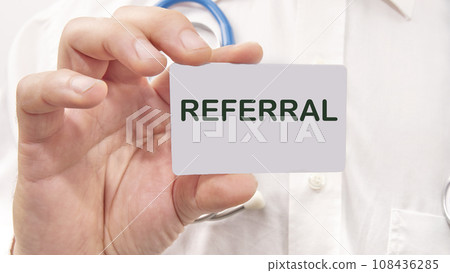 referral word on the card in a man's hand on the background of a white shirt 108436285