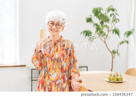 senior woman drinking champagne 108436347