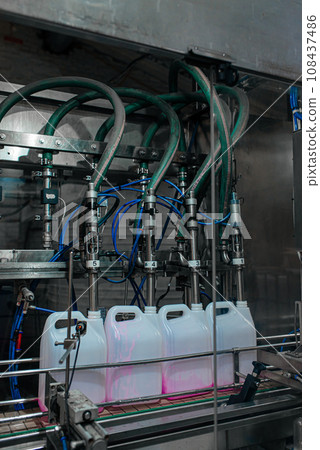 Filling bottles with water, Bottling factorys, plastic canisters, Empty plastic jerrycans moving on conveyor belt of automatic pet blow molding machine at factory 108437486