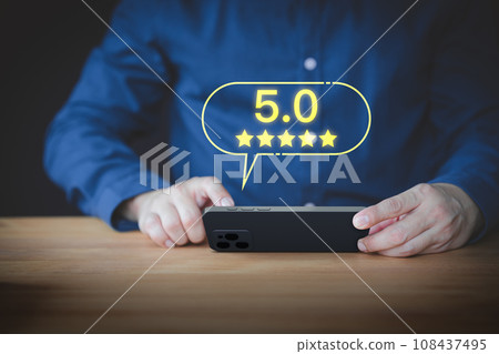 User hand using a mobile phone with pop up five stars icon for feedback review satisfaction service opinion and testimonial. Customer service experience assessment and business satisfaction survey. 108437495
