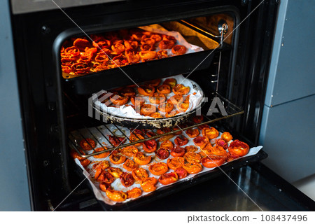 Cooking sun-dried tomatoes in the oven in the kitchen Cooking sun-dried tomatoes in the oven in the kitchen 108437496