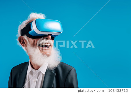 An elderly man wearing virtual reality glasses on a blue background. An elderly man wearing virtual reality glasses on a blue background. 108438713