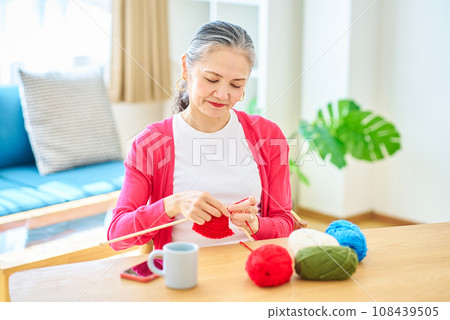 Senior woman enjoying knitting yarn Senior woman enjoying knitting yarn 108439505