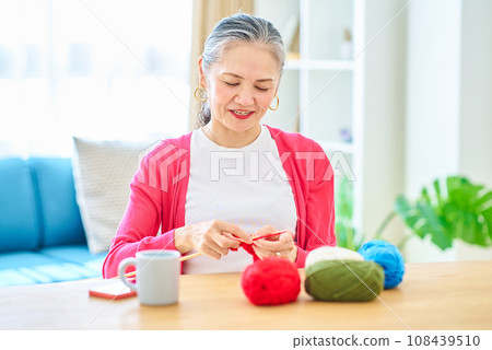 Senior woman enjoying knitting yarn Senior woman enjoying knitting yarn 108439510
