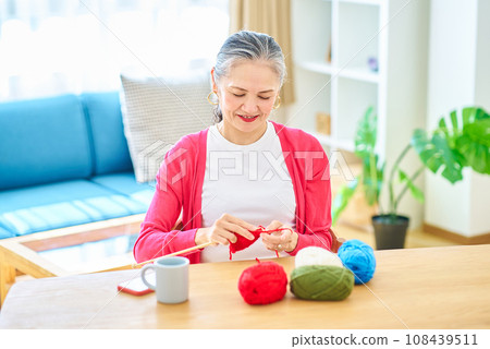 Senior woman enjoying knitting yarn Senior woman enjoying knitting yarn 108439511