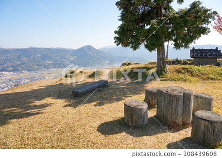 Looking down on the town at the foot from a park bench on a hill 108439608