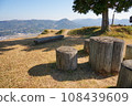 Looking down on the town at the foot from a park bench on a hill 108439609