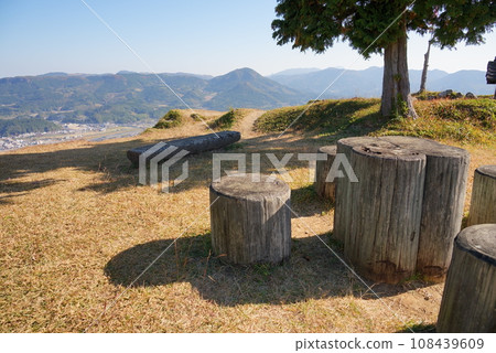 Looking down on the town at the foot from a park bench on a hill 108439609