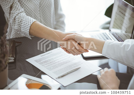 Business people signing contract papers while sitting at the glass table in office, closeup. Partners or lawyers working together at meeting. Teamwork, partnership, success concept Business people signing contract papers while sitting at the glass table in office, closeup. Partners or lawyers working together at meeting. Teamwork, partnership, success concept 108439751
