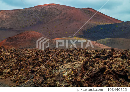 Amazing panoramic landscape of volcano in Timanfaya national park. Popular touristic in Lanzarote island Canary islans Spain. Artistic picture. Travel concept Amazing panoramic landscape of volcano in Timanfaya national park. Popular touristic in Lanzarote island Canary islans Spain. Artistic picture. Travel concept 108440823