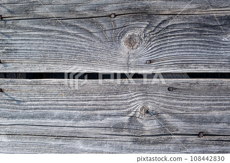 Elements of the walls of a wooden old village house. Wooden Log cabin walls texture. Weathered surface of an old wooden log house close-up. Old wooden log building in winter close-up. Elements of the walls of a wooden old village house. Wooden Log cabin walls texture. Weathered surface of an old wooden log house close-up. Old wooden log building in winter close-up. 108442830