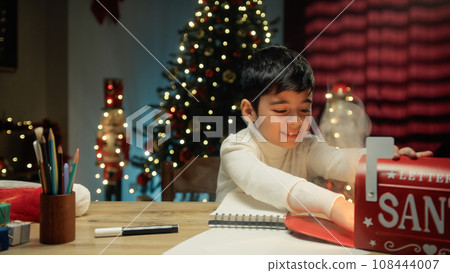 Kid sending Christmas letter to Santa Claus letterbox Kid sending Christmas letter to Santa Claus letterbox 108444007