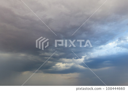 Dark storm clouds in sky before thunderstorm and rain. Dramatic sky background 108444660