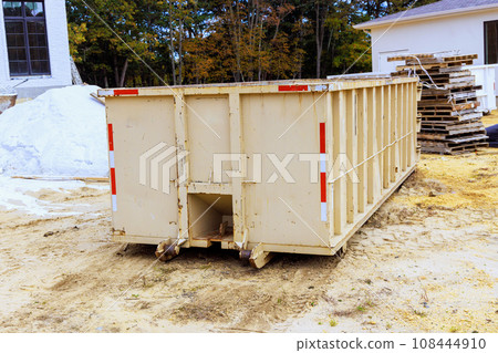 Loaded dumpster for construction waste debris near construction site 108444910