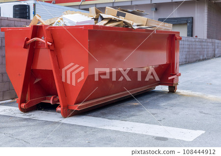 Near construction site, there is dumpster loaded with construction waste debris Near construction site, there is dumpster loaded with construction waste debris 108444912