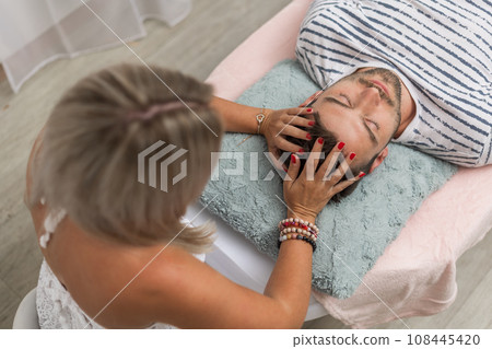 Woman healer performing access bars to a man, an alternative medicine concept 108445420