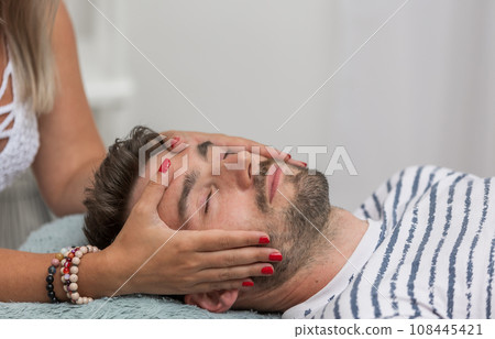 The woman healer performing method access or conciousness bars, alternative medicine concept, pseudoscientific method of alternative medicine that focuses on massaging various points on the head 108445421
